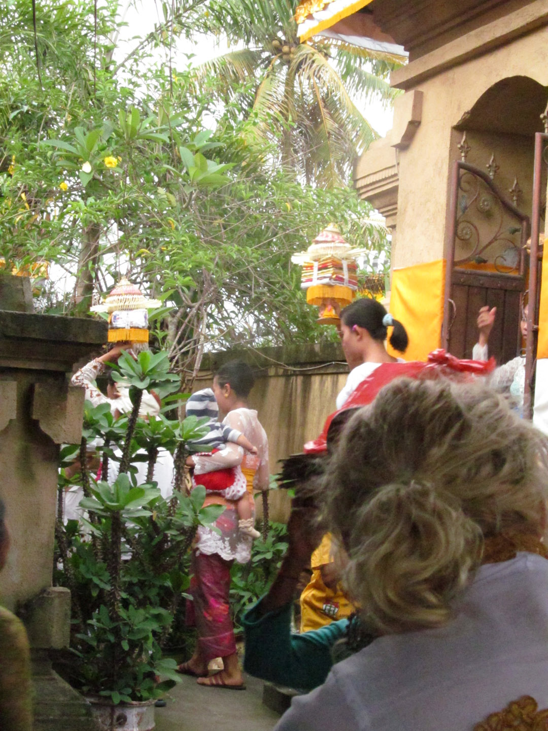 Offerings for the ceremony begin to arrive. Many women are practiced in carrying burdens on their head in Bali.
